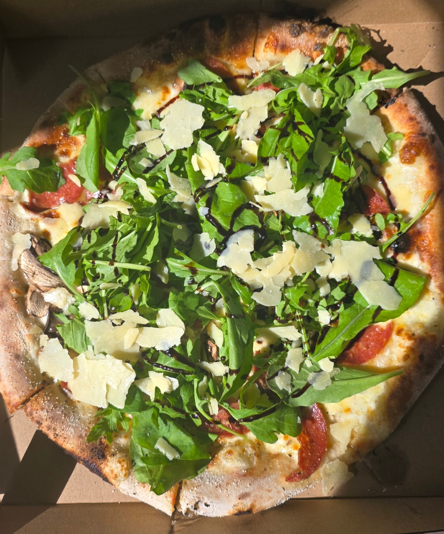 Pizza with rocket, shaved parmigiano and balsamic glaze