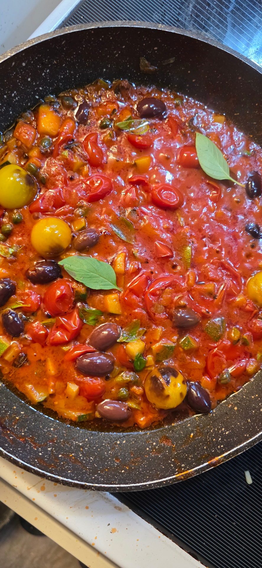 Fresh tomato and olive sugo simmering in the pan